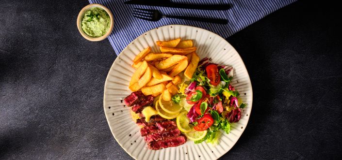 Odrezak sa puterom, ukiseljenim limunom, zelenom salatom i krompirićima sa majonezom i zhougom