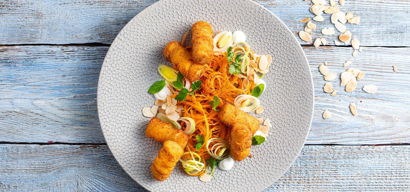 AVIKO Pom' Croquettes posluženi sa salatom od praziluka, peršunom, šargarepom, pečenim bademom, jogurtom i svežom mentom